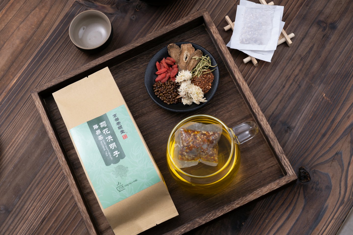 Getrocknete chinesische Teekräuter und goldener Tee in einer Tasse.